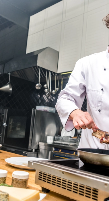 Smiling chef frying meat in restaurant kitchen 2023 11 27 05 26 53 utc 1 2024 05 20 231204 usjf